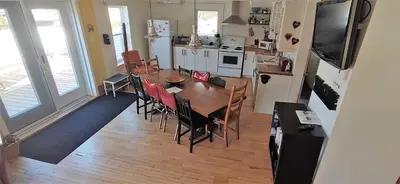 a kitchen and dining room with a table and chairs at Auberge Le Sunshine in Stanstead Plain