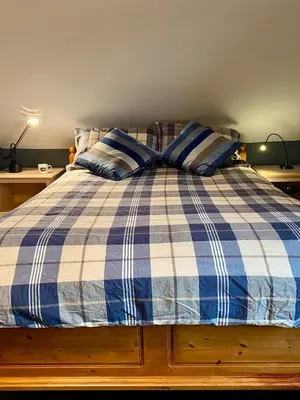 a blue and white bed with two pillows on it at Auberge Le Sunshine in Stanstead Plain