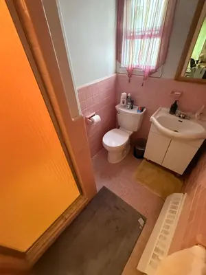 a bathroom with a toilet and a sink at Downtown Montreal Airport 15Mins in Montréal