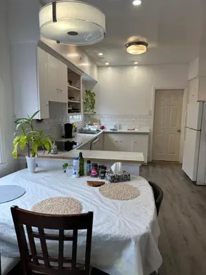 a kitchen with a table with a white table cloth at Downtown Montreal Airport 15Mins in Montréal