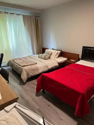 a bedroom with two beds and a red blanket at Downtown Montreal Airport 15Mins in Montréal