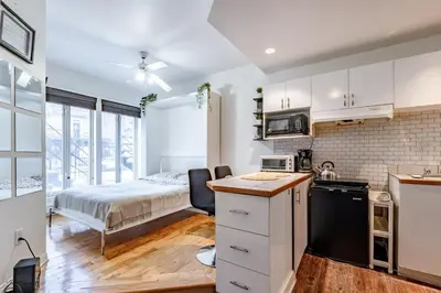 a kitchen and a bedroom with a bed in a room at Studio COZY - Rue Ste-Catherine in Montréal