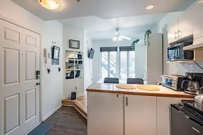 a kitchen with white cabinets and a counter top at Studio COZY - Rue Ste-Catherine in Montréal