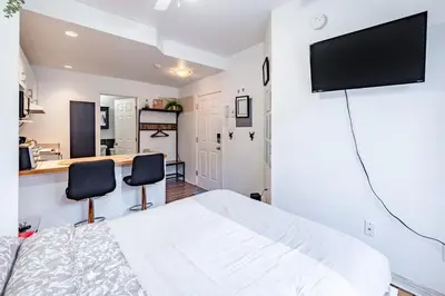 a bedroom with a bed and two chairs at Studio COZY - Rue Ste-Catherine in Montréal