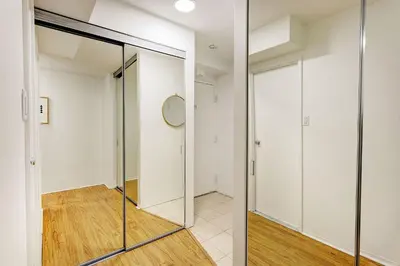 a hallway with a glass door and a clock at LaCité Apartments Modern Comfort Close to Downtown Montreal in Montréal