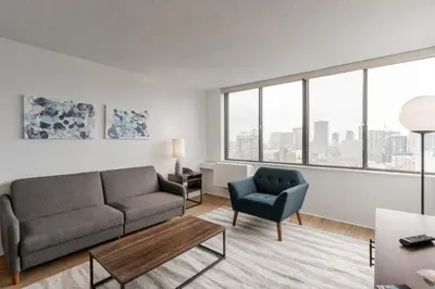 a living room with a couch and a chair at LaCité Apartments Modern Comfort Close to Downtown Montreal in Montréal