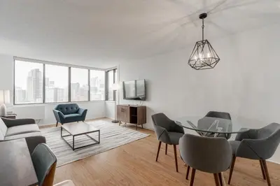 a living room with a glass table and chairs at LaCité Apartments Modern Comfort Close to Downtown Montreal in Montréal