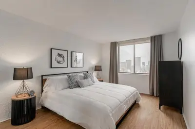 a bedroom with a large bed and a large window at LaCité Apartments Modern Comfort Close to Downtown Montreal in Montréal