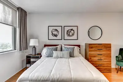 a bedroom with a large white bed and a window at LaCité Apartments Modern Comfort Close to Downtown Montreal in Montréal