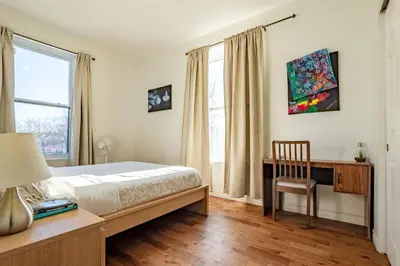 a bedroom with a bed and a desk and window at Apartment ROOMY - Plateau Mont-Royal in Montréal