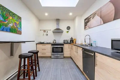 a kitchen with wooden cabinets and a counter with stools at Apartment ROOMY - Plateau Mont-Royal in Montréal