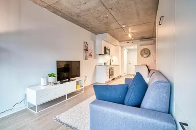 a living room with a blue couch and a tv at Welcome Chez Milou in Montréal