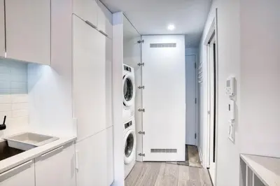 a white laundry room with two washer and dryer at Welcome Chez Milou in Montréal