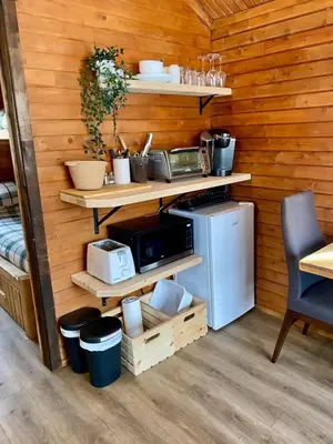 a kitchen with wooden walls with shelves and a microwave at Chalet 3 - Domaine de l Archipel in Sorel