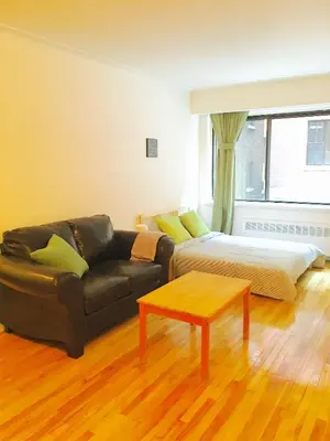 a living room with a couch and a bed at Stylish Montreal Apartment Comfortable Stay in the Golden Square Mile in Montréal