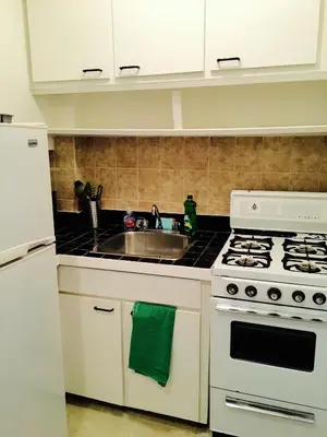 a kitchen with a white stove and a sink at Stylish Montreal Apartment Comfortable Stay in the Golden Square Mile in Montréal