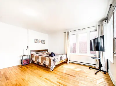 a bedroom with a bed and a flat screen tv at Spacious 4-Bedrooms in HoMa Montreal 22 in Montréal