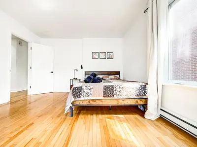 a bedroom with a bed and a wooden floor at Spacious 4-Bedrooms in HoMa Montreal 22 in Montréal