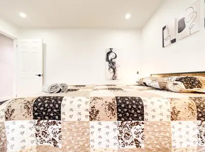 a bedroom with a bed with a quilt on it at Spacious 4-Bedrooms in HoMa Montreal 22 in Montréal