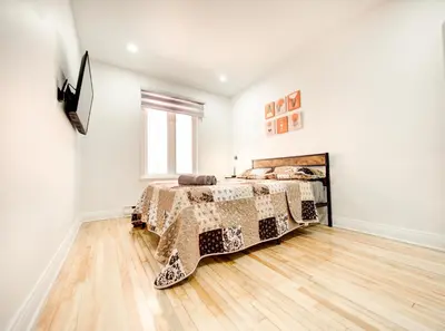 a bedroom with a bed and a window at Spacious 4-Bedrooms in HoMa Montreal 22 in Montréal