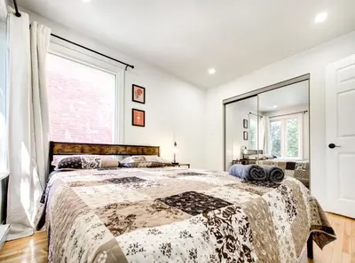 a bedroom with a bed and a large window at Spacious 4-Bedrooms in HoMa Montreal 22 in Montréal