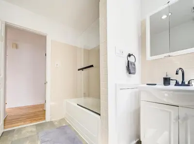 a white bathroom with a sink and a shower at Spacious 4-Bedrooms in HoMa Montreal 22 in Montréal