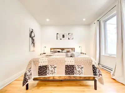 a bedroom with a bed and a window at Spacious 4-Bedrooms in HoMa Montreal 22 in Montréal
