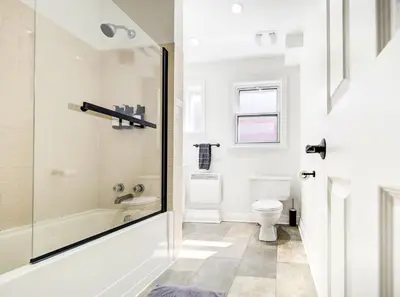 a white bathroom with a shower and a toilet at Spacious 4-Bedrooms in HoMa Montreal 22 in Montréal
