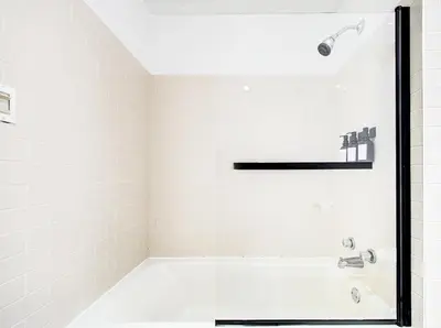 a white bathroom with a tub and a shower at Spacious 4-Bedrooms in HoMa Montreal 22 in Montréal