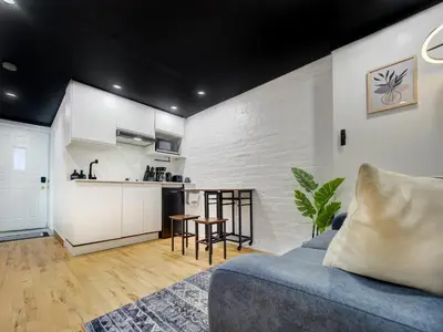 a living room with a couch and a kitchen at Stylish-24 1-Bedroom in HoMa Montreal in Montréal