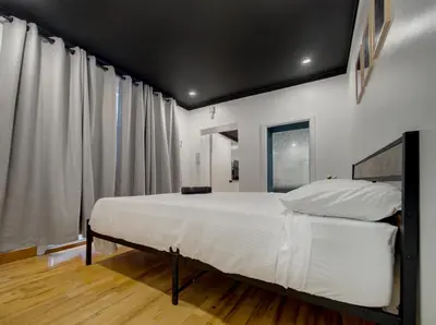 a bedroom with a large white bed with white sheets at Stylish-24 1-Bedroom in HoMa Montreal in Montréal