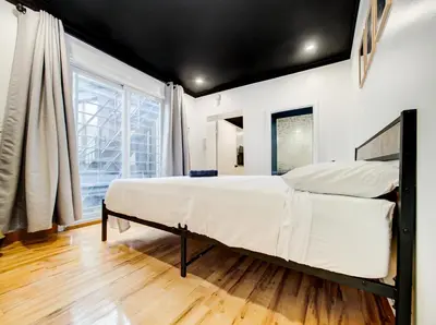 a bedroom with a large bed and a large window at Stylish-24 1-Bedroom in HoMa Montreal in Montréal