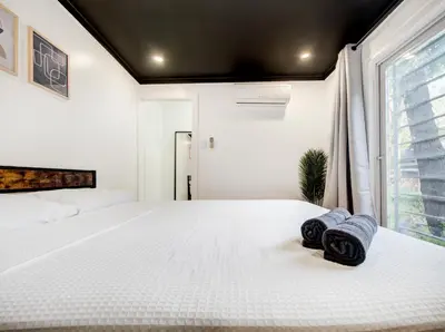 a bedroom with a white bed with towels on it at Stylish-24 1-Bedroom in HoMa Montreal in Montréal