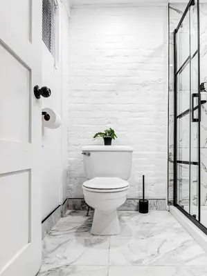 a white bathroom with a toilet with a potted plant at Stylish-24 1-Bedroom in HoMa Montreal in Montréal