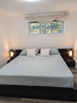 a bedroom with a bed with two pillows and a window at Lac et Montagne Eastman in Eastman