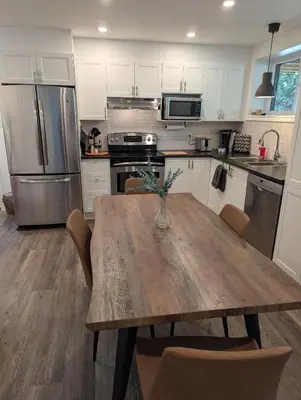 a kitchen with a wooden table with chairs around it at Lac et Montagne Eastman in Eastman