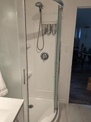a shower with a glass door in a bathroom at Lac et Montagne Eastman in Eastman