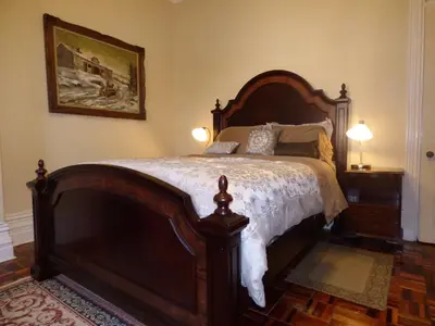 a bedroom with a large wooden bed and two lamps at Gingerbread Manor in Montréal