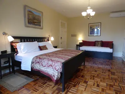 a bedroom with a bed and a bench in it at Gingerbread Manor in Montréal