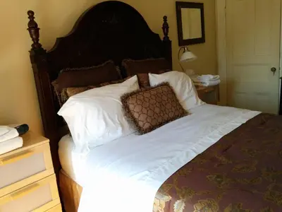 a bedroom with a large bed with white sheets and pillows at Gingerbread Manor in Montréal