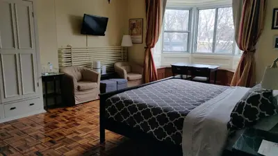 a bedroom with a bed and a living room at Gingerbread Manor in Montréal