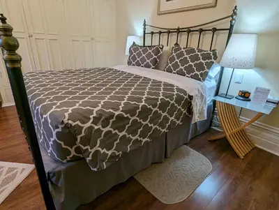 a bedroom with a large bed with a wooden floor at Gingerbread Manor in Montréal