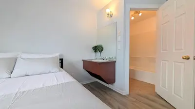 a bedroom with a bed and a sink and a door at Hotel Room in Varennes in Varennes