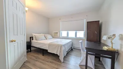 a bedroom with a bed and a desk and a window at Hotel Room in Varennes in Varennes