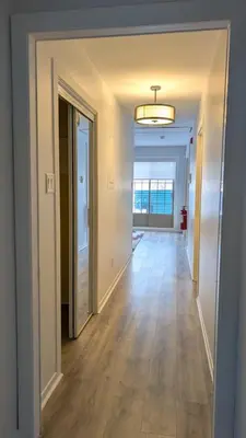 an empty hallway of a home with a hard wood floor at Hotel Room in Varennes in Varennes