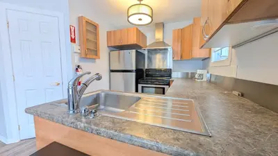 a kitchen with a sink and a stove top oven at Hotel Room in Varennes in Varennes