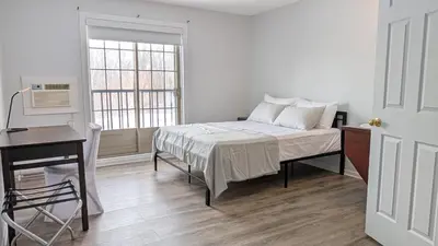 a bedroom with a bed and a desk and a window at Hotel Room in Varennes in Varennes
