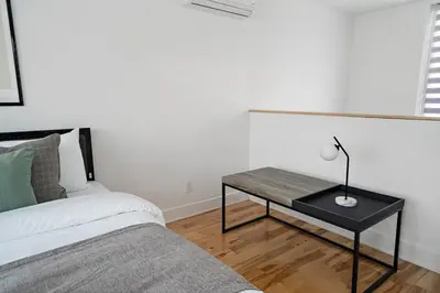 a bedroom with a bed and a table with a lamp at 3 bedroom Penthouse Great for family vacation in Montréal