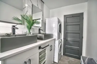 a white bathroom with two sinks and a refrigerator at Sherby LUX - Central, Parking, Renovated, Sleeps 6 in Sherbrooke