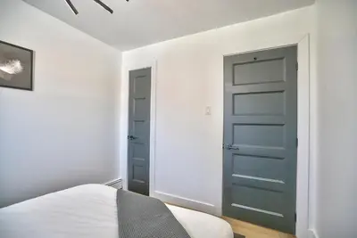 a bedroom with a green door and a bed at Sherby LUX - Central, Parking, Renovated, Sleeps 6 in Sherbrooke